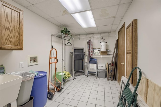 washroom with light tile patterned floors, laundry area, washer hookup, and a sink