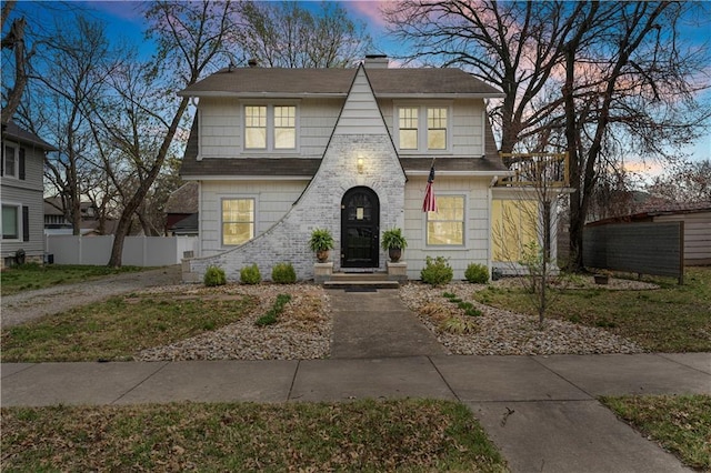 view of front of house featuring fence, a chimney, and roof with shingles