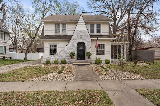 view of front of home featuring fence, a chimney, and roof with shingles
