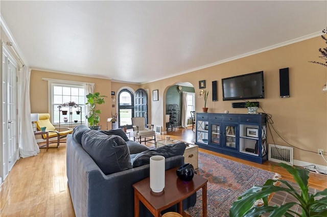 319 S Elm St, Ottawa, KS 66067 - living area with arched walkways, ornamental molding, and light wood-style flooring