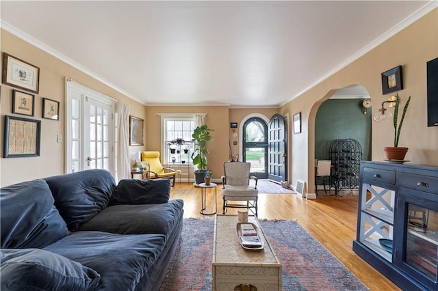 319 S Elm St, Ottawa, KS 66067 - living area featuring ornamental molding, arched walkways, and light wood-style floors