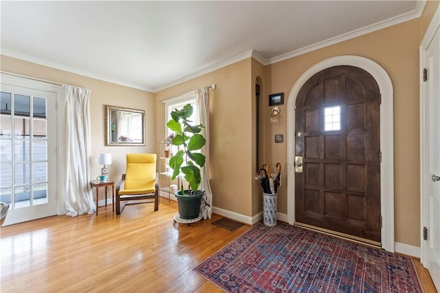 319 S Elm St, Ottawa, KS 66067 - entryway with arched walkways, light wood-type flooring, and crown molding