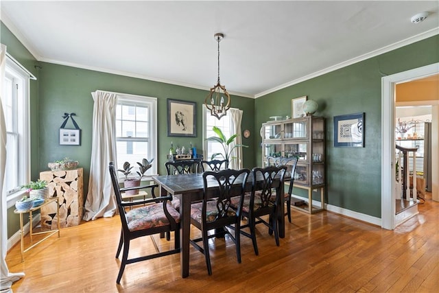 319 S Elm St, Ottawa, KS 66067 - dining space with hardwood / wood-style flooring, ornamental molding, and a chandelier