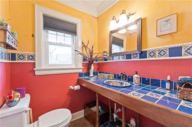 319 S Elm St, Ottawa, KS 66067 - half bath featuring tile walls, a wainscoted wall, crown molding, and tile patterned floors