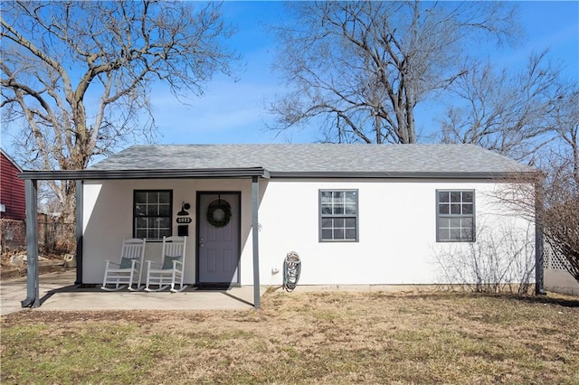 single story home with a shingled roof, fence, a front lawn, and stucco siding