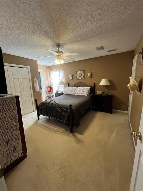 bedroom with a closet, light colored carpet, ceiling fan, and visible vents