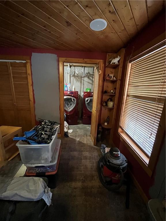 corridor featuring lofted ceiling, wood ceiling, plenty of natural light, and washing machine and clothes dryer