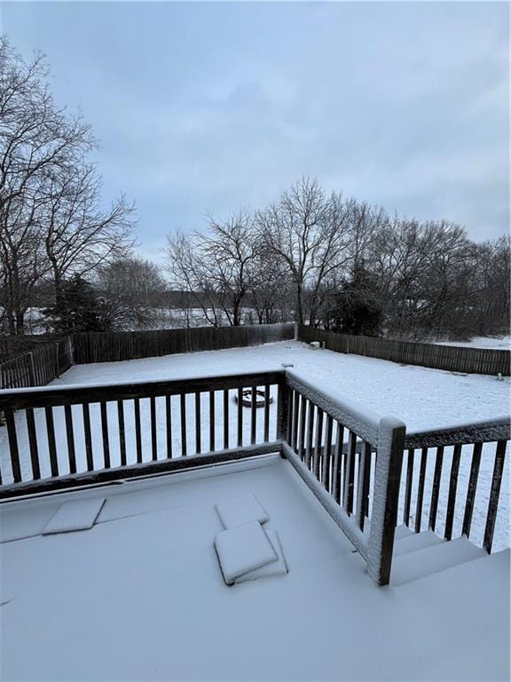 snow covered deck featuring a fenced backyard