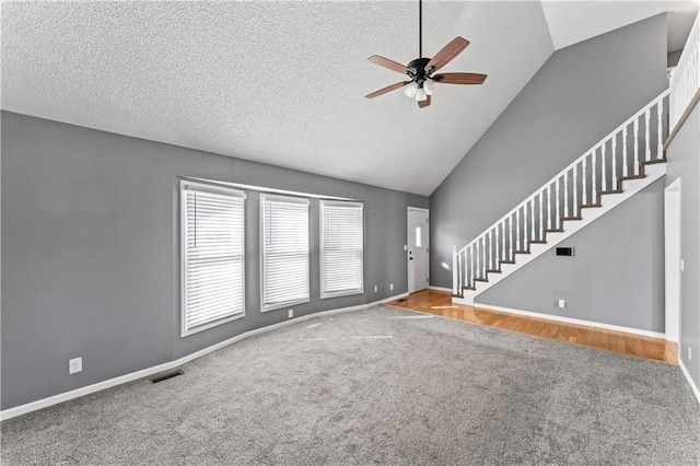 unfurnished living room with visible vents, vaulted ceiling, stairway, and ceiling fan