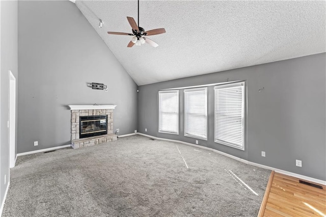 unfurnished living room featuring baseboards, visible vents, and a stone fireplace