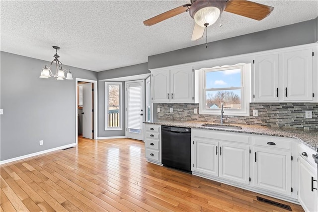 kitchen featuring light stone counters, hanging light fixtures, white cabinets, a sink, and dishwasher