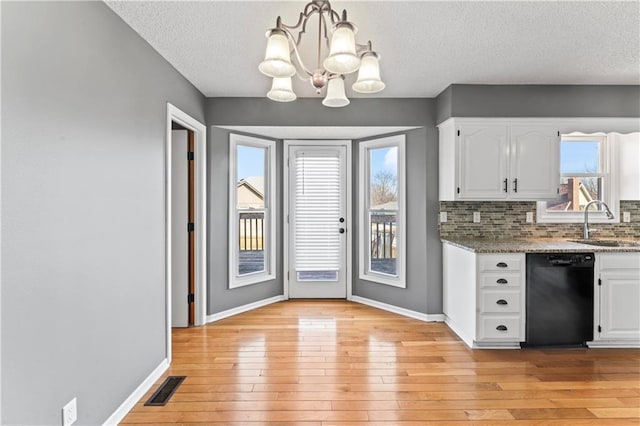 kitchen with a sink, white cabinetry, dishwasher, and decorative light fixtures