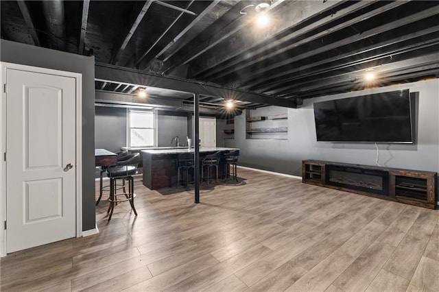 interior space featuring a sink, indoor bar, and wood finished floors