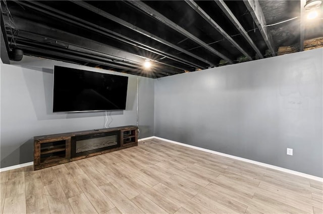 finished basement featuring light wood finished floors and baseboards