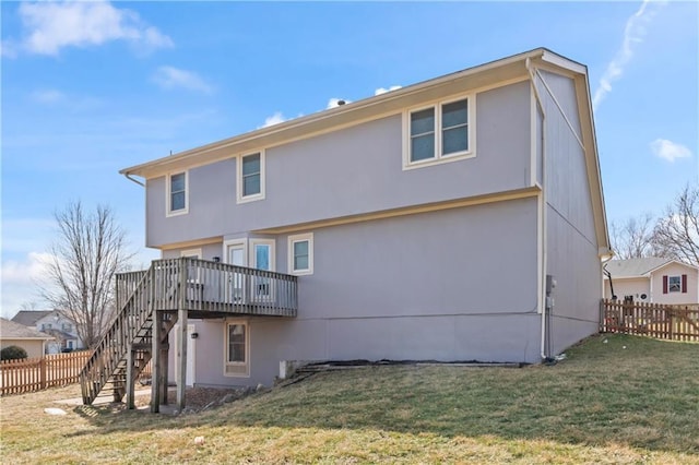 back of property with stairs, a yard, a deck, and fence