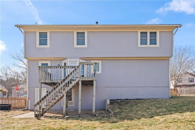 rear view of house featuring stairs, a yard, fence, and a wooden deck