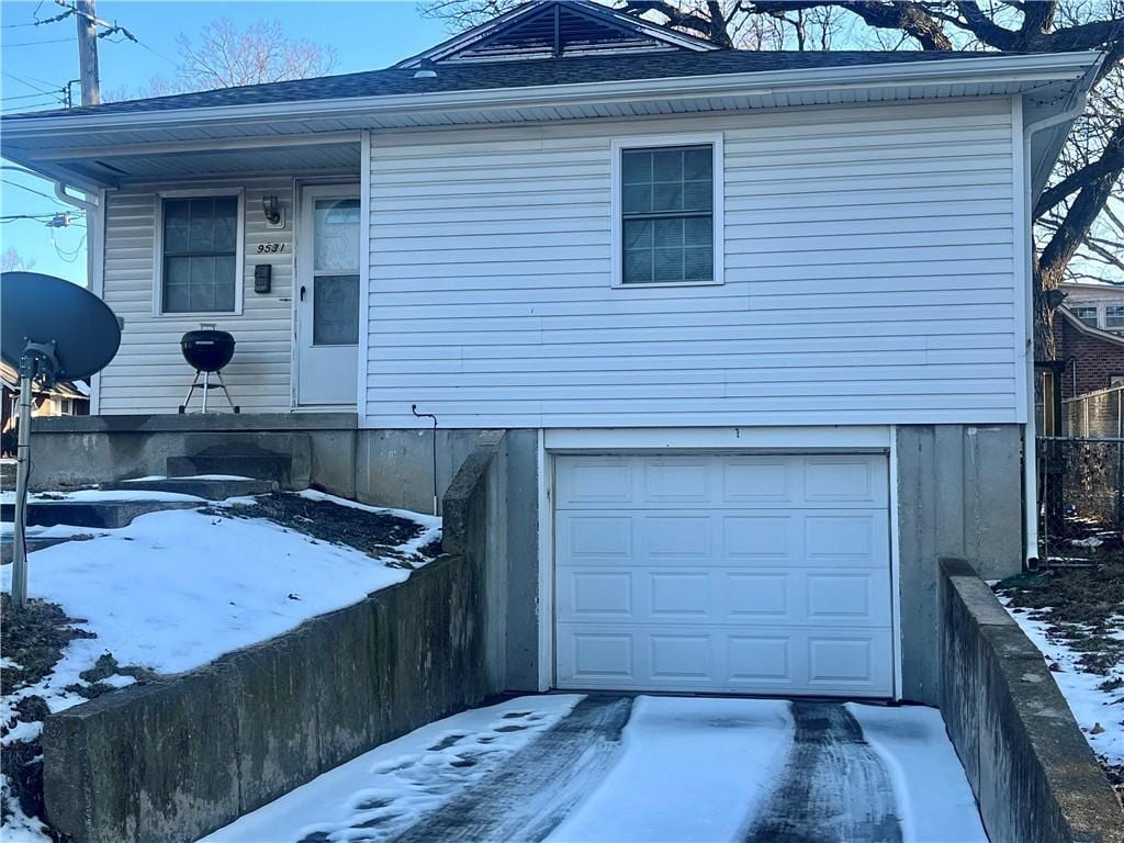 view of front of property featuring an attached garage and fence