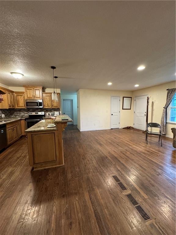 1403 E Mechanic St, Harrisonville, MO 64701 - kitchen featuring a center island, appliances with stainless steel finishes, and dark wood-type flooring