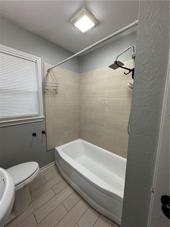 1403 E Mechanic St, Harrisonville, MO 64701 - full bath with bathtub / shower combination, wood finish floors, and toilet
