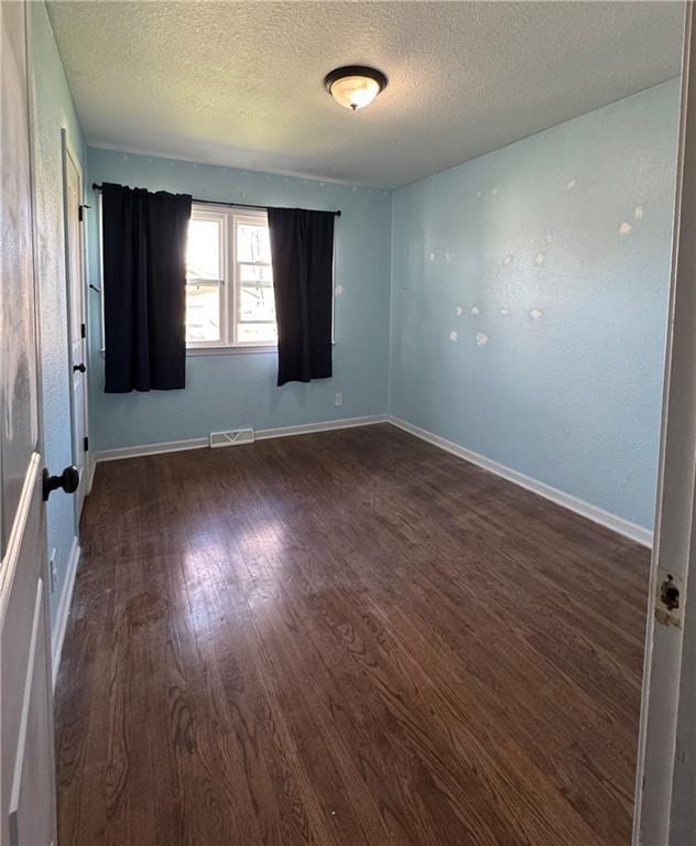 1403 E Mechanic St, Harrisonville, MO 64701 - unfurnished room featuring baseboards, a textured ceiling, visible vents, and wood finished floors