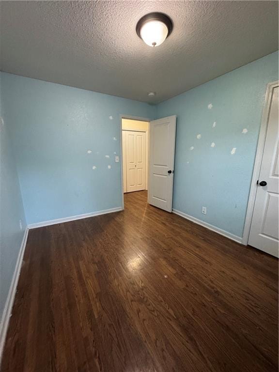 1403 E Mechanic St, Harrisonville, MO 64701 - empty room with baseboards, a textured ceiling, and wood finished floors