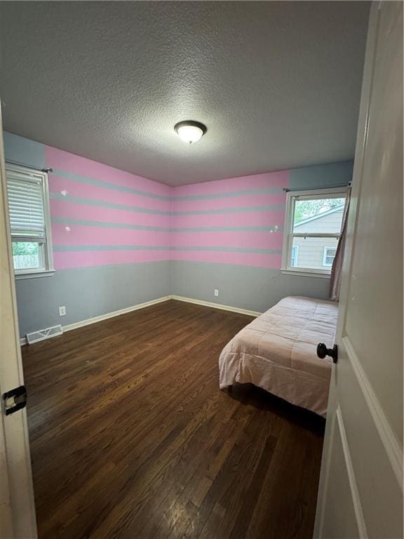 1403 E Mechanic St, Harrisonville, MO 64701 - bedroom featuring a textured ceiling, visible vents, multiple windows, and wood finished floors
