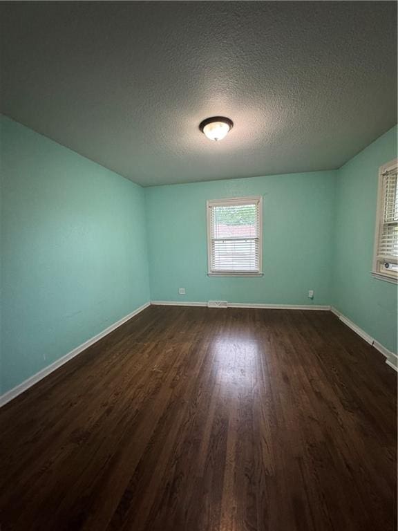 1403 E Mechanic St, Harrisonville, MO 64701 - spare room with dark wood-style flooring, a textured ceiling, and baseboards