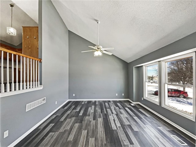 spare room with lofted ceiling, dark wood-style floors, visible vents, and baseboards