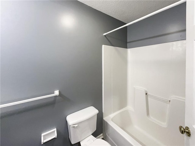 full bathroom featuring a textured ceiling, bathtub / shower combination, and toilet