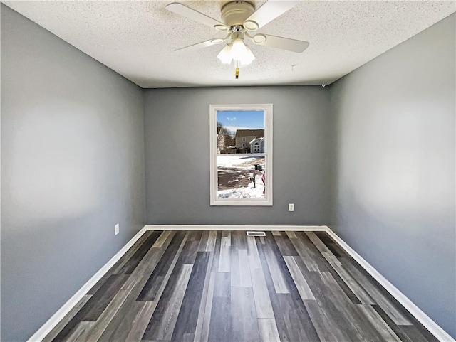 unfurnished room with a ceiling fan, a textured ceiling, baseboards, and dark wood-style flooring