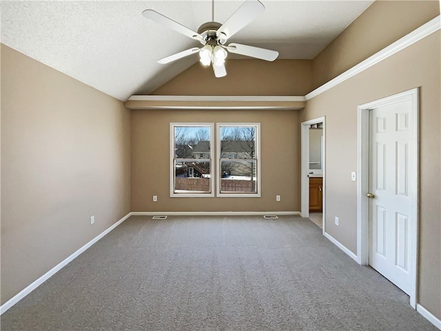 empty room with vaulted ceiling, light carpet, ceiling fan, and baseboards