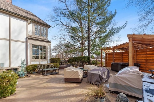 wooden deck with a hot tub, grilling area, and a pergola