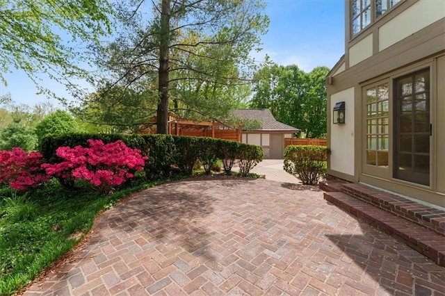view of patio featuring an outdoor structure and fence