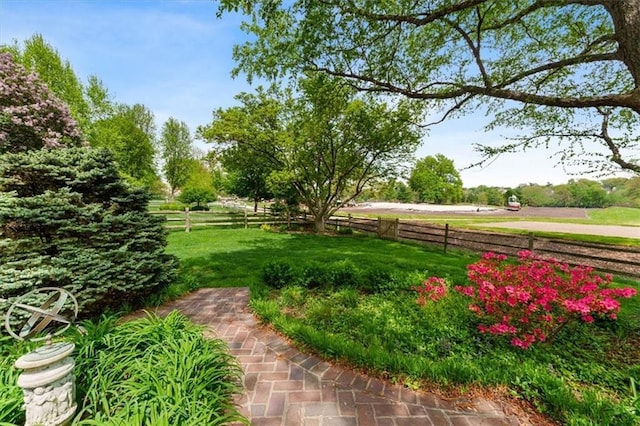 view of yard with fence and a rural view