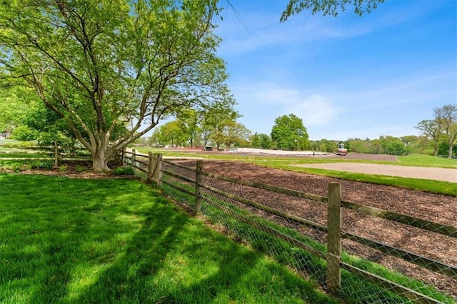 view of yard with fence and a rural view