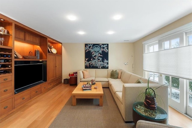 living area featuring a healthy amount of sunlight, light wood-style floors, and recessed lighting