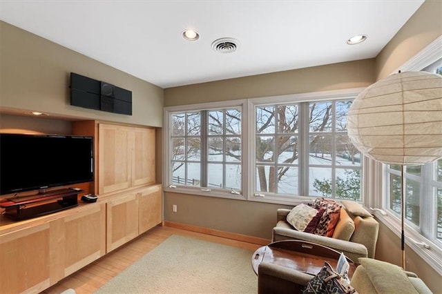 interior space featuring visible vents, light wood finished floors, baseboards, and a wealth of natural light