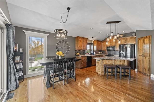 20880 W 224th St, Spring Hill, KS 66083 - dining area with vaulted ceiling, healthy amount of natural light, a chandelier, light wood-type flooring, and a textured ceiling
