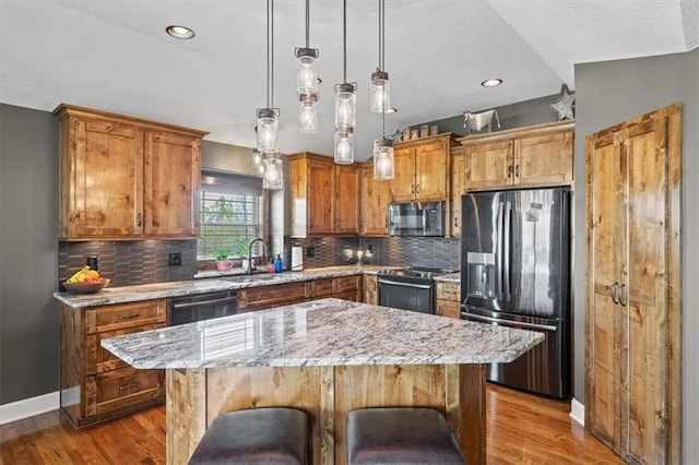 20880 W 224th St, Spring Hill, KS 66083 - kitchen with stainless steel fridge with ice dispenser, black stove, dishwasher, brown cabinetry, and a center island