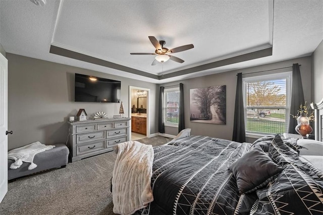 20880 W 224th St, Spring Hill, KS 66083 - carpeted bedroom with a tray ceiling, a textured ceiling, multiple windows, connected bathroom, and ceiling fan
