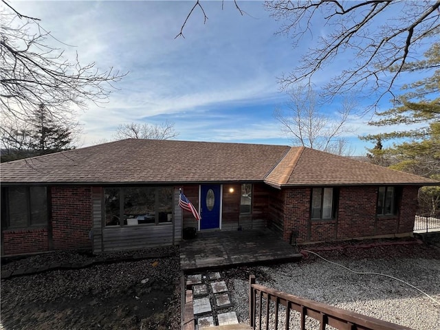 back of property featuring a shingled roof, a patio area, and brick siding