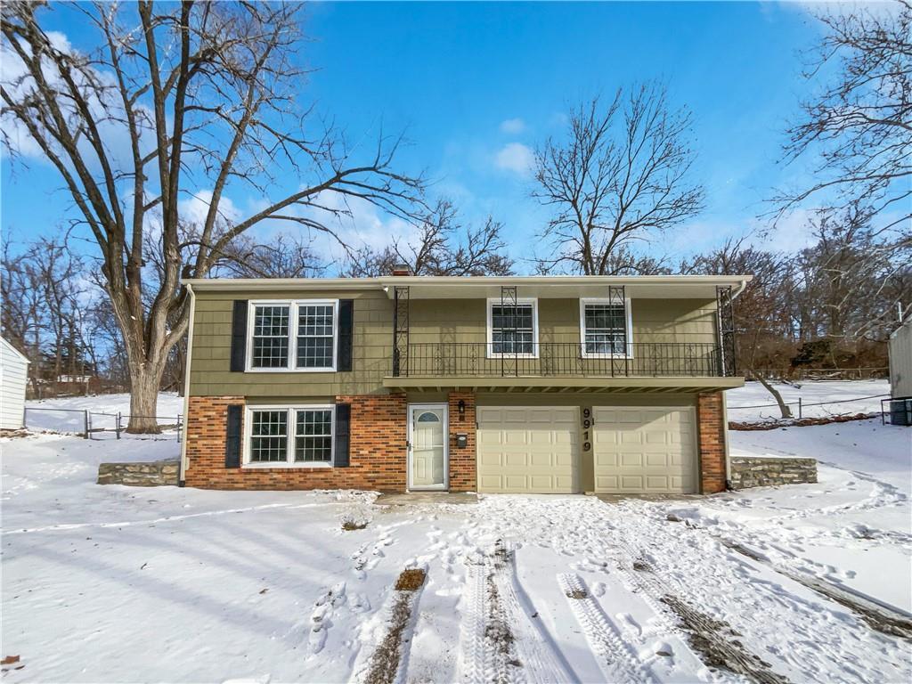 9919 Harrison St, Kansas City, MO 64131 - view of front of home featuring brick siding and a garage