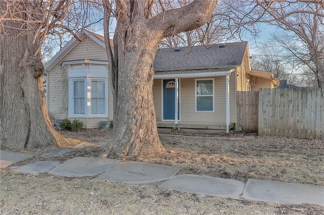 view of front of house with a shingled roof and fence