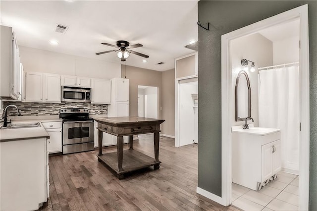 kitchen featuring backsplash, visible vents, stainless steel appliances, and a sink