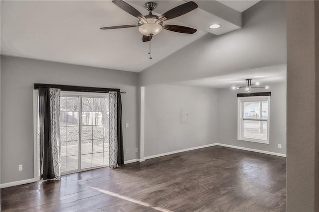 spare room featuring lofted ceiling, baseboards, dark wood-style flooring, and ceiling fan with notable chandelier