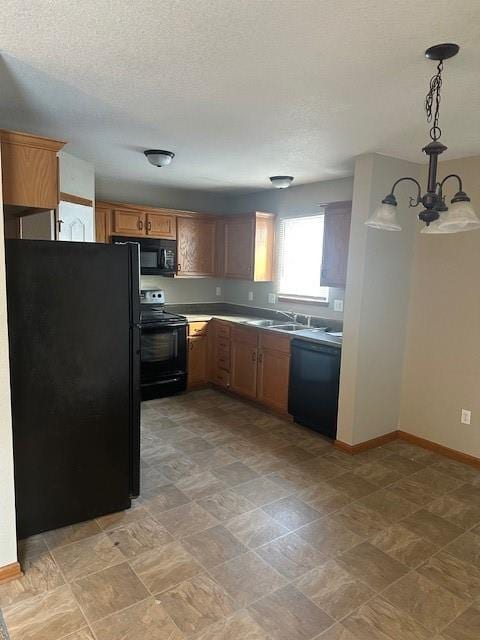 kitchen with black appliances, brown cabinetry, light countertops, and decorative light fixtures