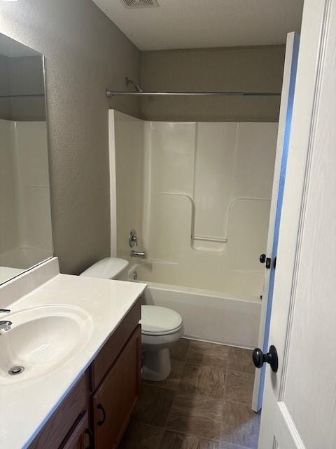 bathroom with visible vents, vanity, bathtub / shower combination, and toilet