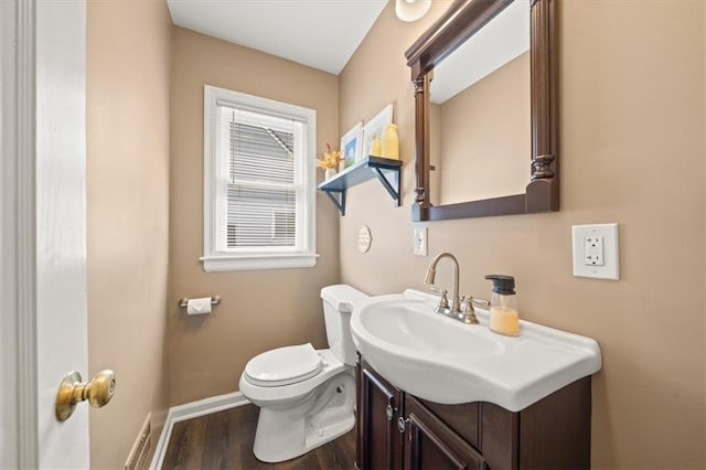 bathroom with vanity, wood finished floors, toilet, and baseboards