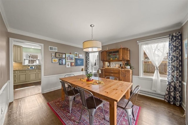 dining area with dark wood-style floors, a wainscoted wall, visible vents, and ornamental molding