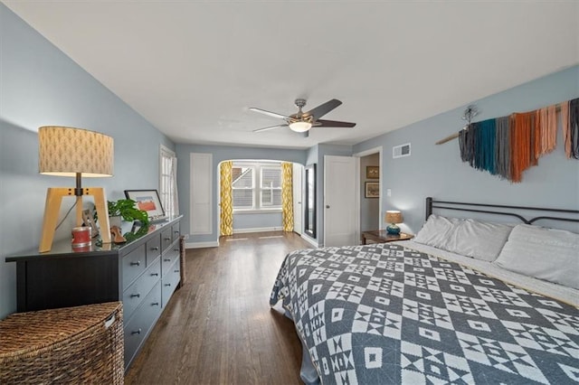 bedroom with visible vents, ceiling fan, baseboards, and wood finished floors